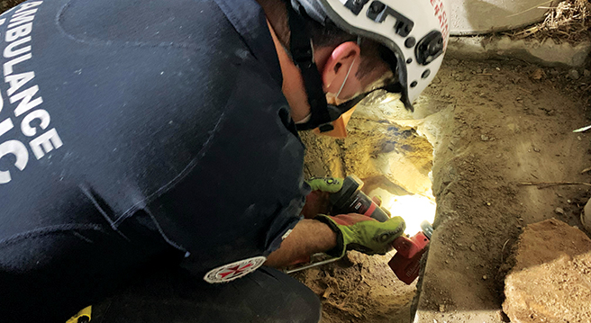 Special Operations Team Rescue Paramedic Adam Ferris cutting through a concrete slab to rescue a trapped puppy 