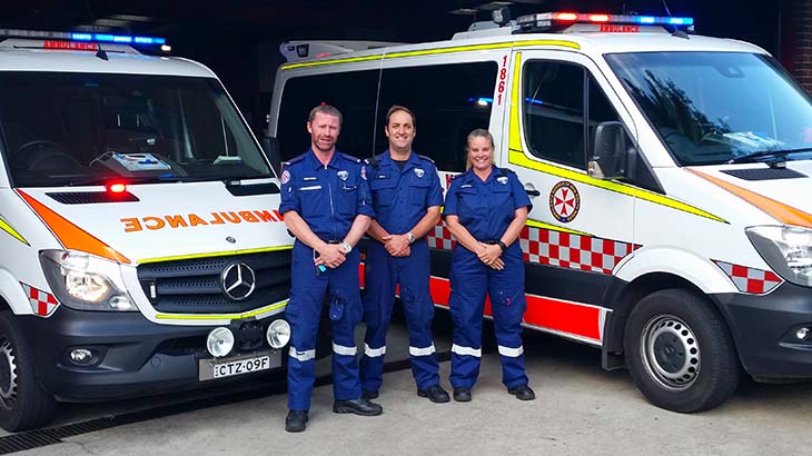 Paramedics with vehicles in the background