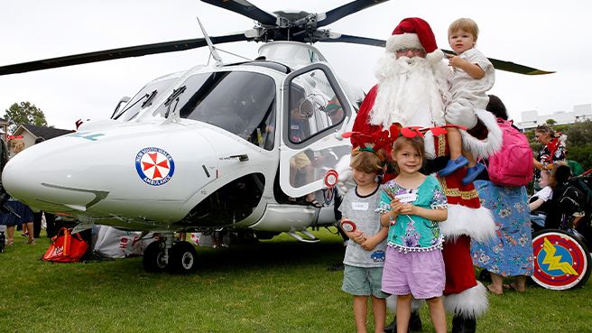 Santa with children next to helicopter